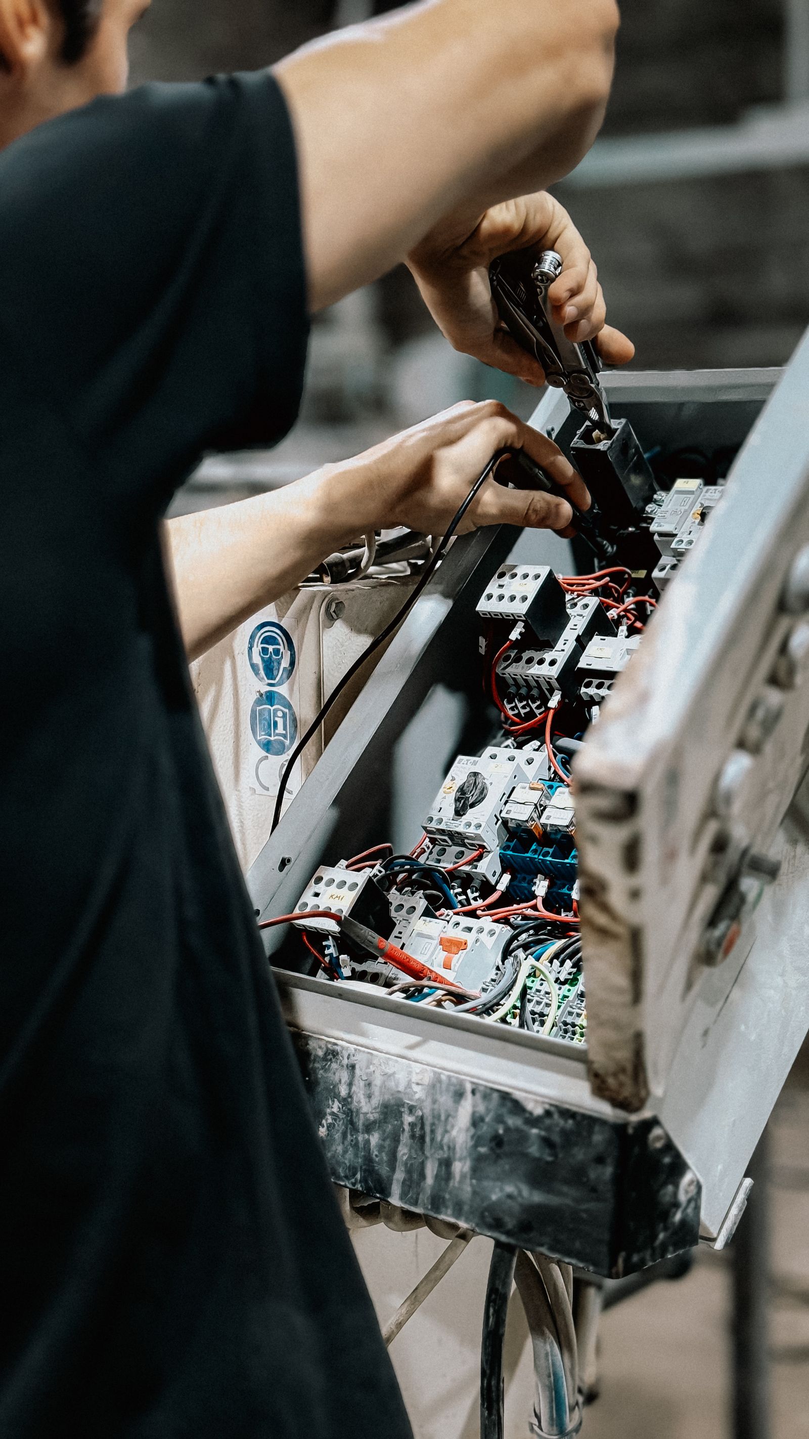 Elevator technician servicing a control panel to demonstrate after-sales maintenance support